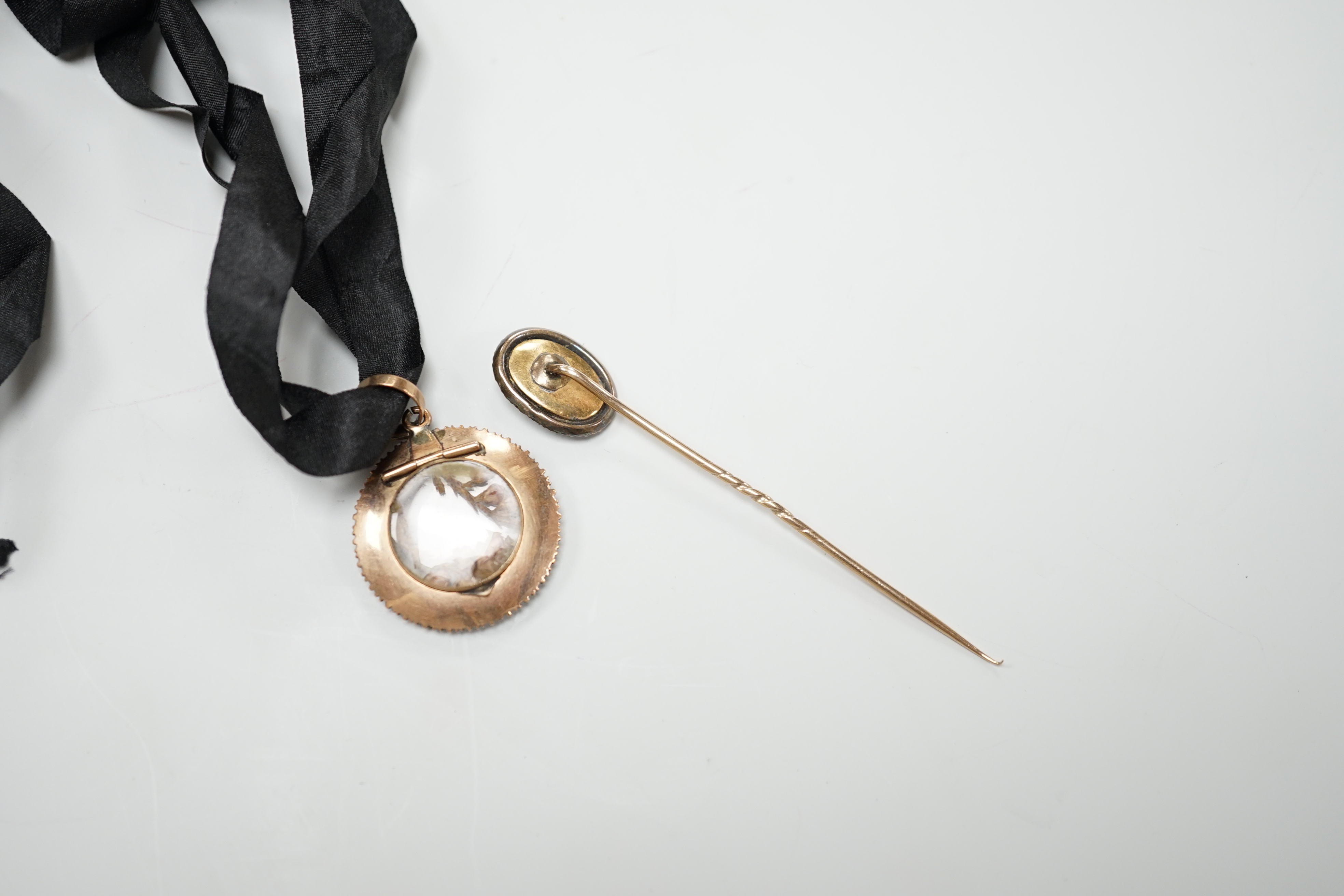 A late Victorian gold and split pearl circular locket, 3.5cm and a Regency stick pin with central bushel of wheat hairwork panel CITES Submission reference YZBJEB1E
